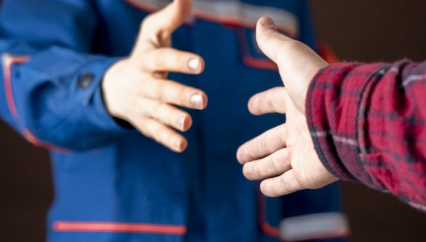 worker in blue uniform having a handshake with his customer